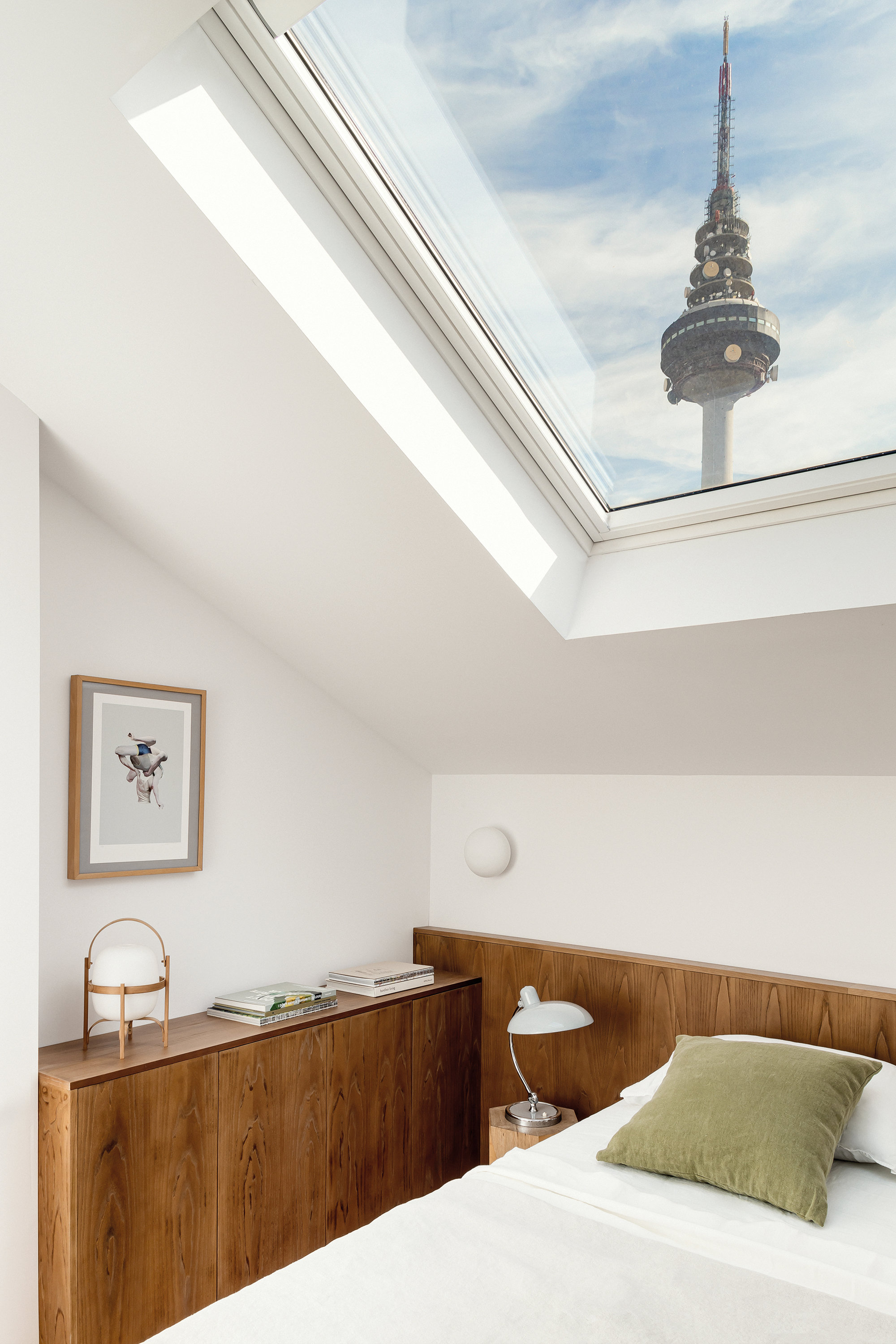habitación con ventana, cama y mueble con lámpara Cestita de Miguel Milá
