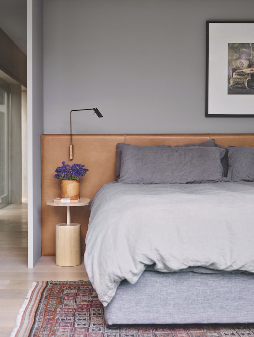dormitorio gris con cabecero de cuero marron