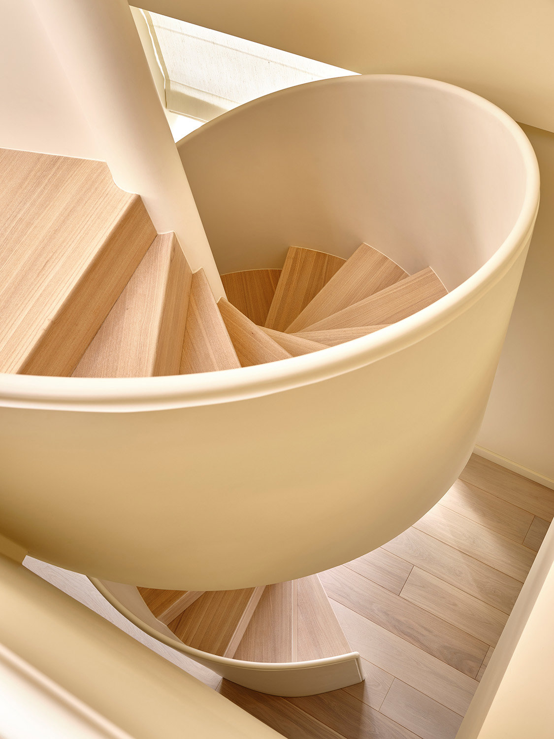 Escalera de espiral minimalista con tonos neutros