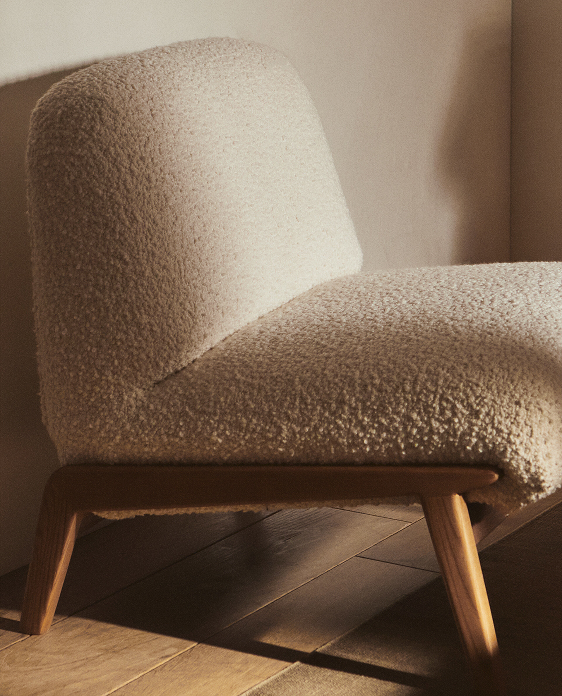 Butaca tapizada con tejido con textura bouclé es perfecta para cualquier rincón.