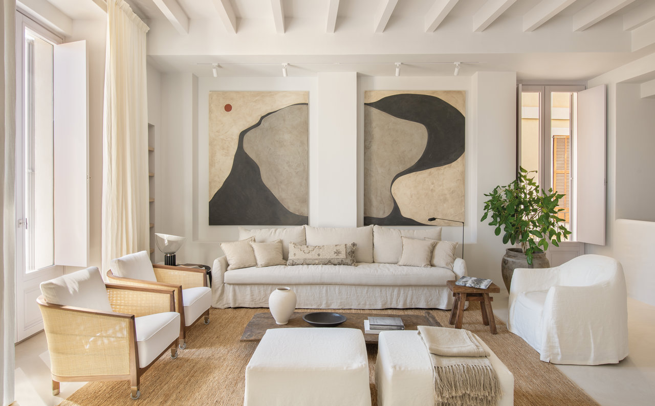 Salón en blanco con cuadro de Jaume Roig y muebles en tonos neutros
