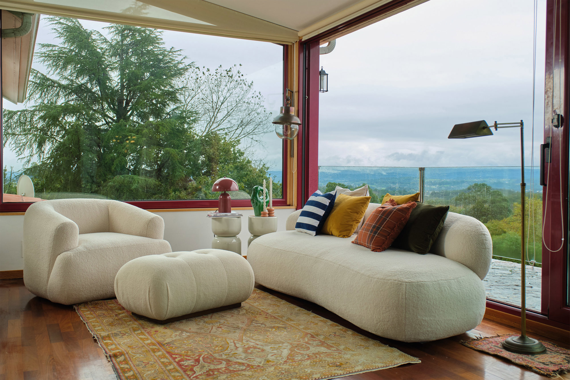 salón con dos sofás curvos y amplios ventanales