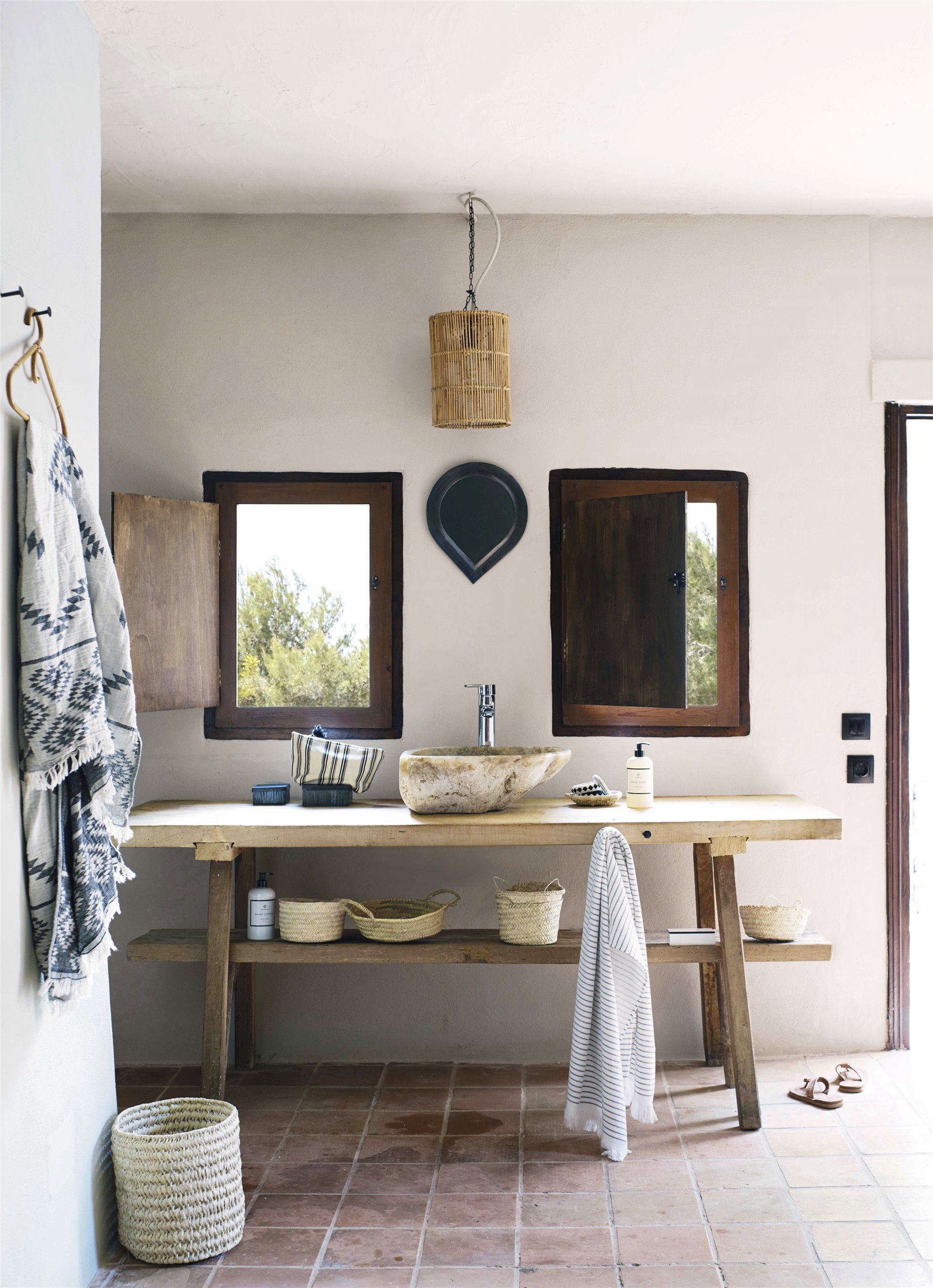 baño de estilo rústico con ventanas al exterior y lavabo de piedra