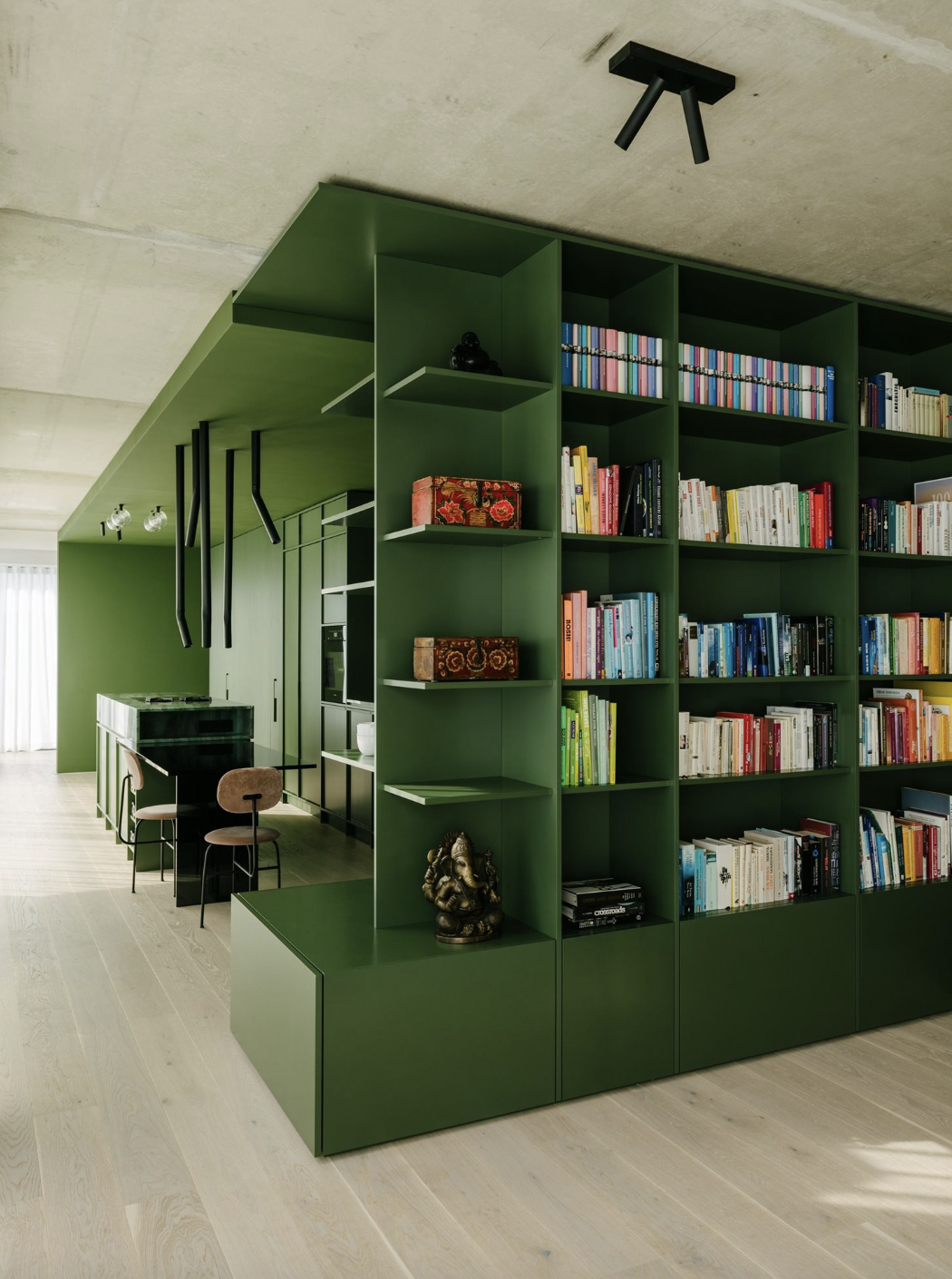 mueble verde con cocina y libreria