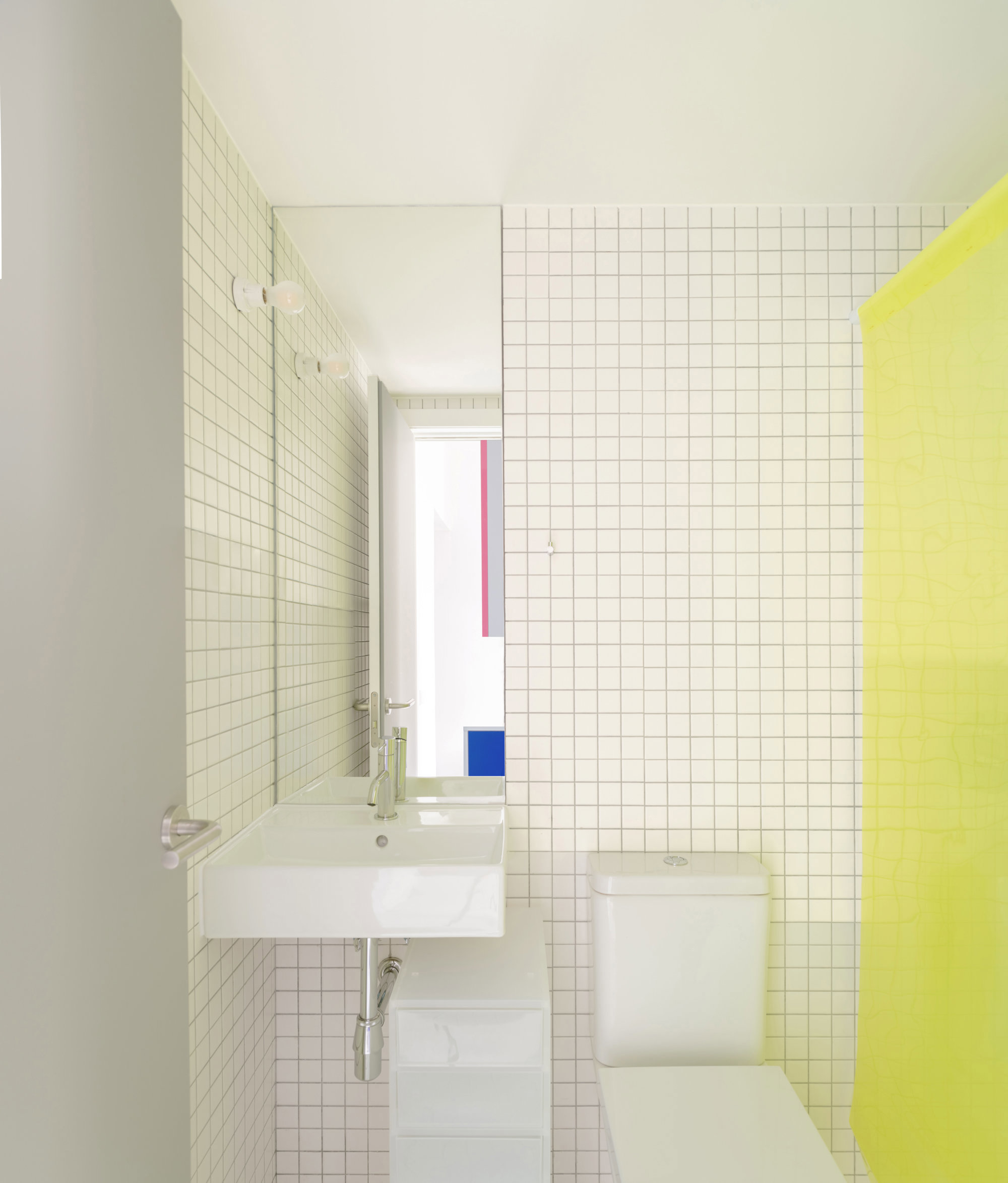 baño blanco con azulejos y detalle amarillo 