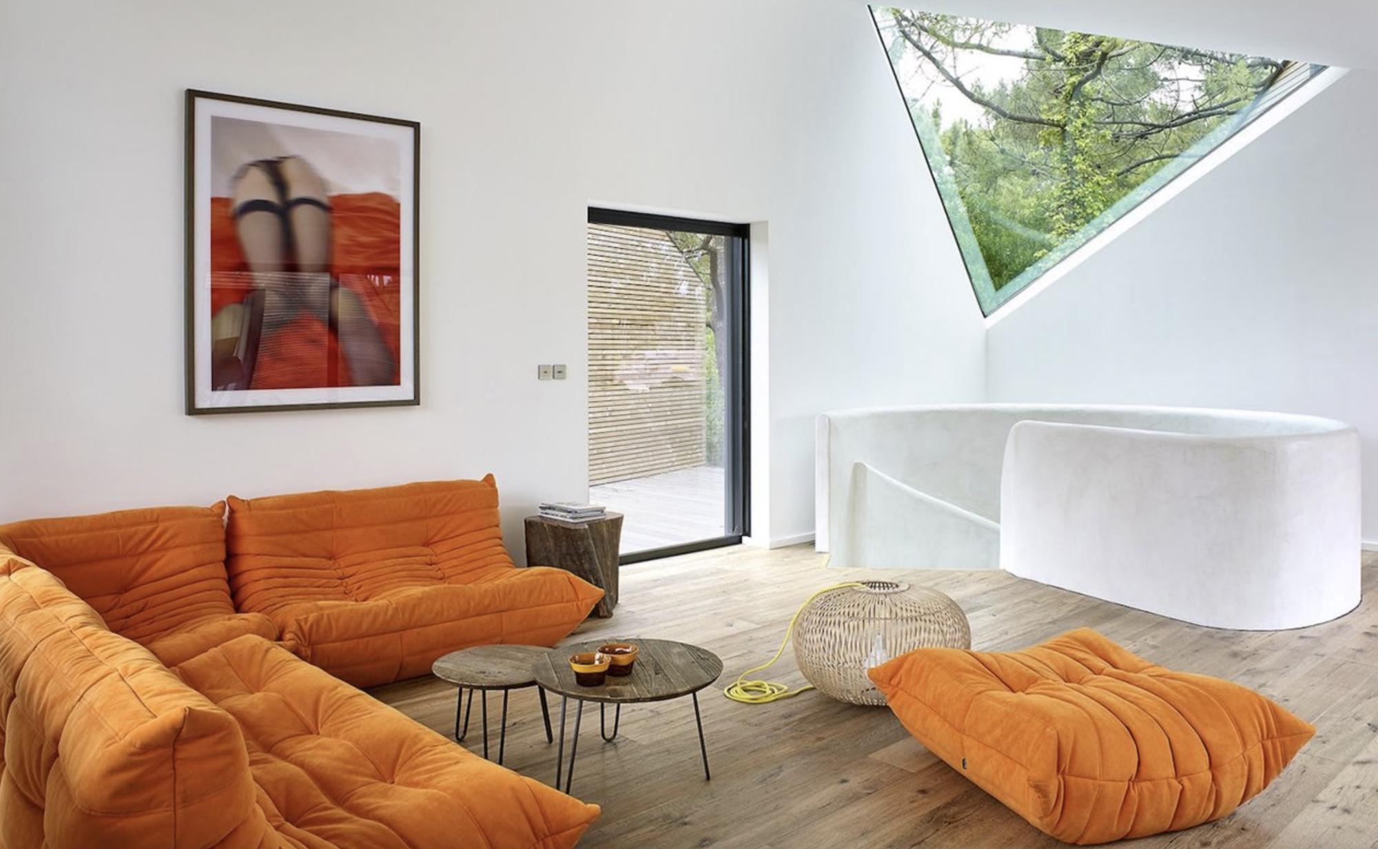 sofas naranjas y ventana triangular