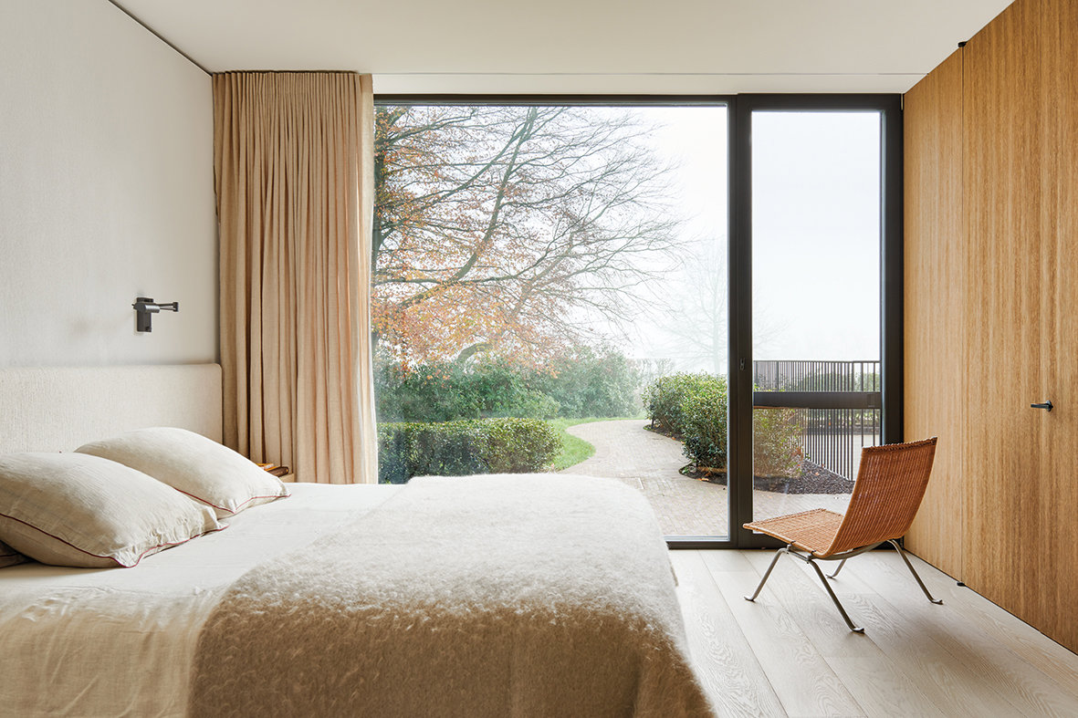 dormitorio principal en blanco y madera con ventanal