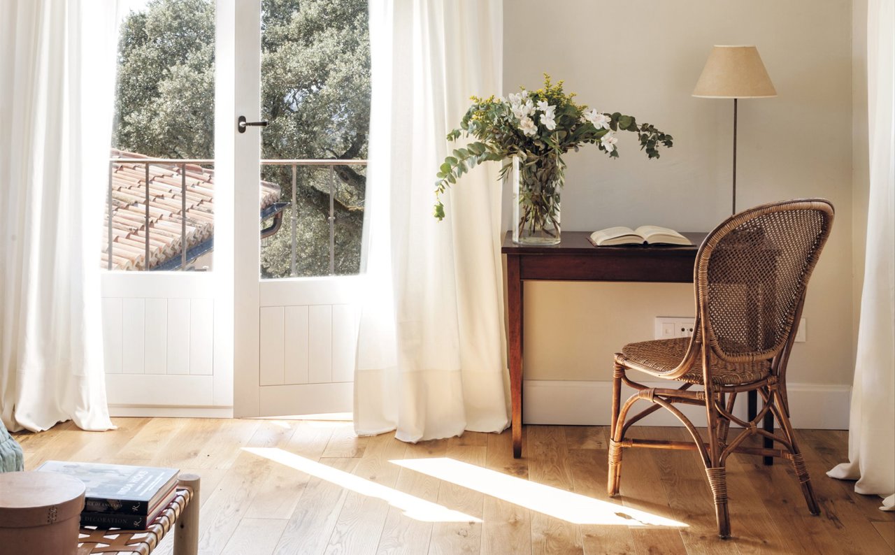 salón estilo rústico romántico blanco y madera con escritorio, flores y cortinas largas