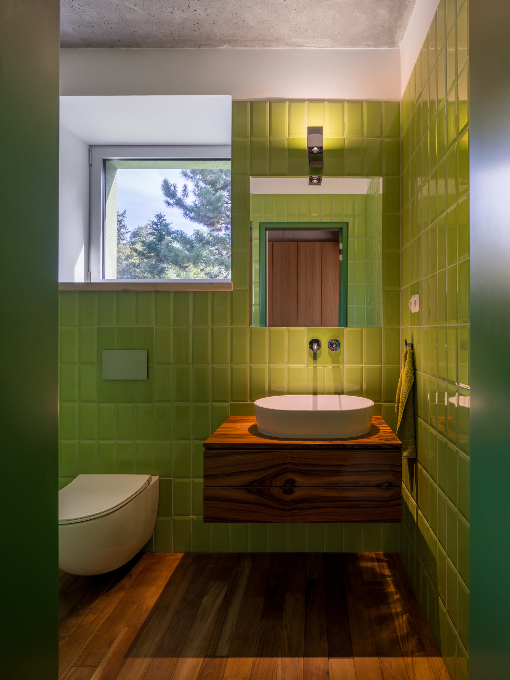 Baño verde con mueble de lavabo de madera