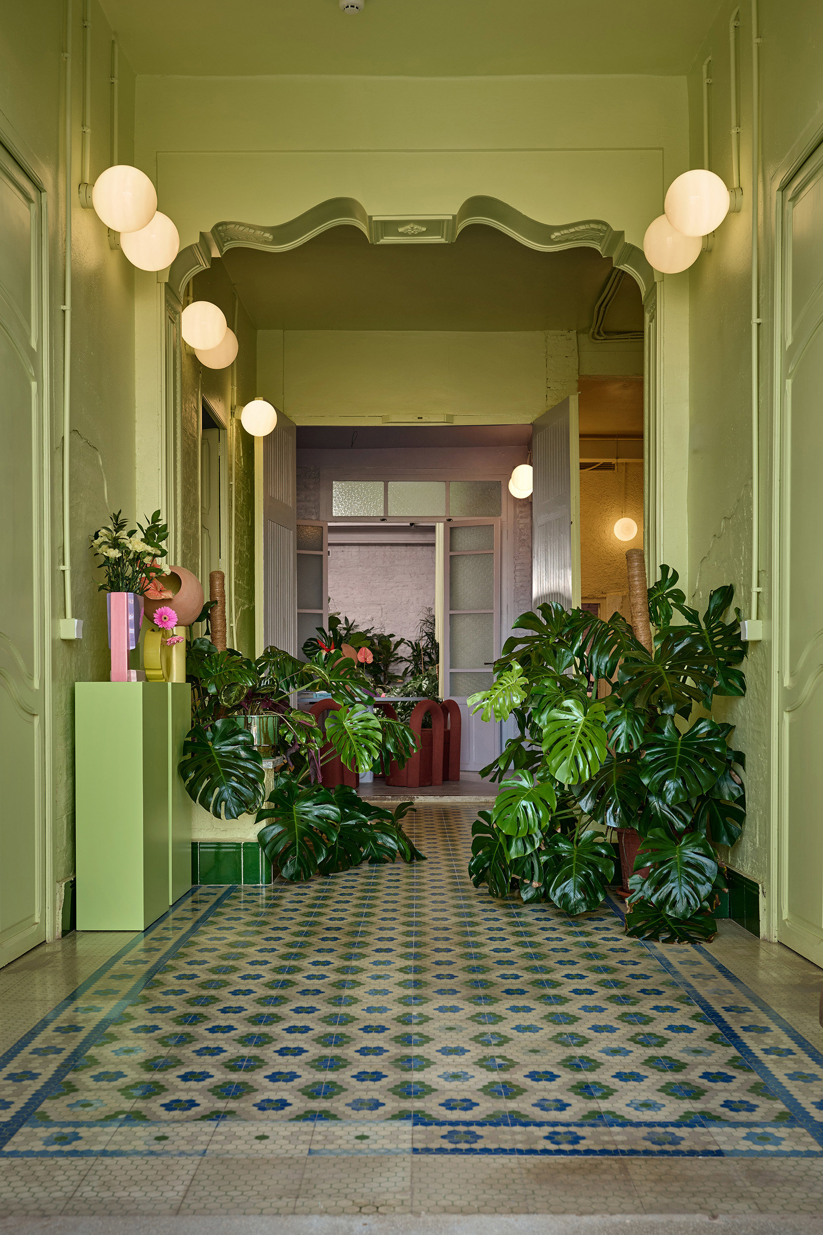 entrada verde con plantas y suelo de mosaico
