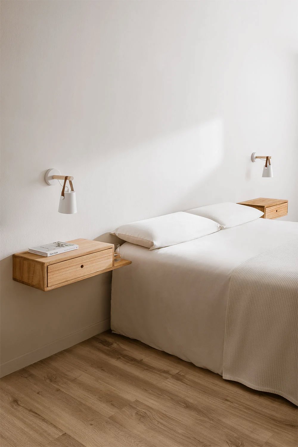 Dormitorio despejado con dos mesitas de noche minimalistas y funcionales de madera clara. 