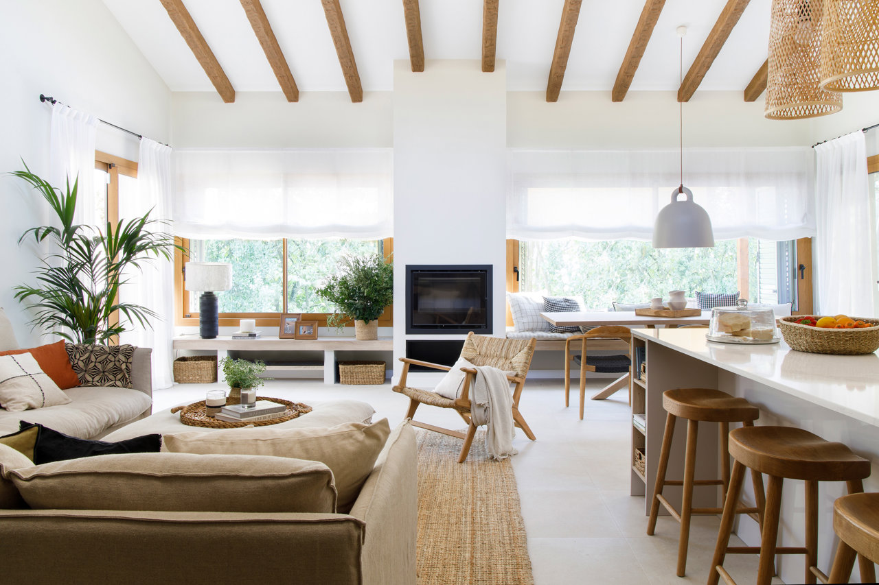 Salón con vigas de madera de estilo minimalista y cálido en una casa de campo.
