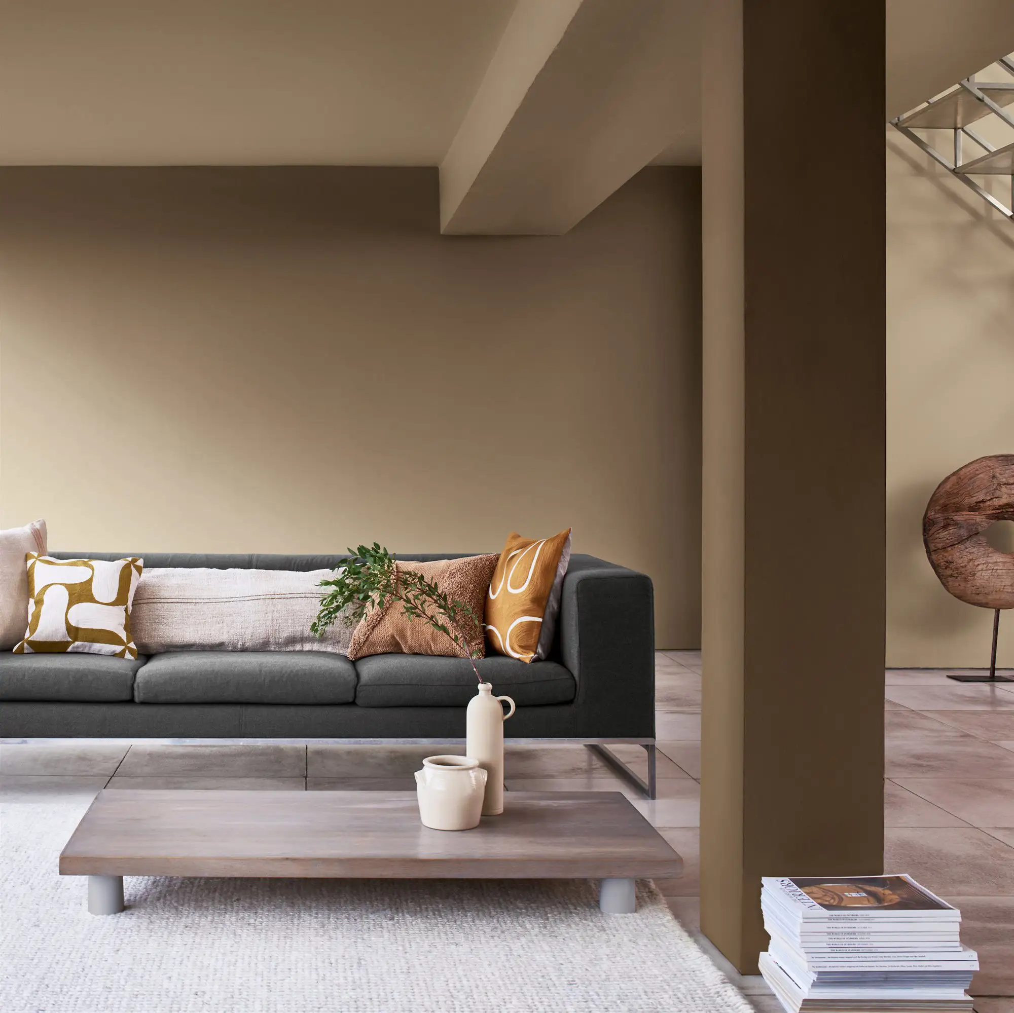 sofa gris, mesa baja y una columna color topo