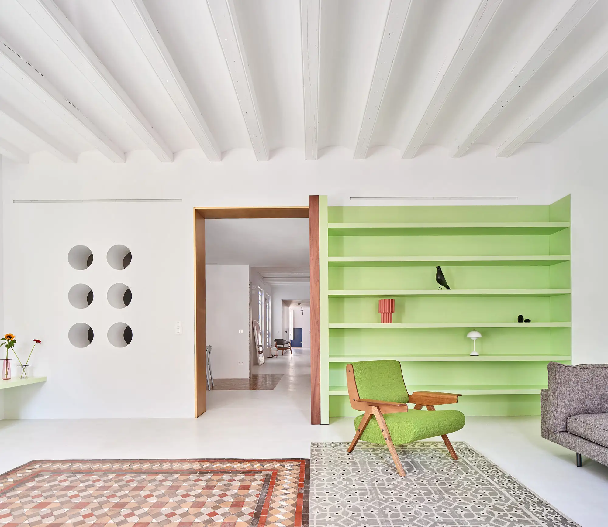 estanteria verde menta, alfombras y pared con ventanas redondas