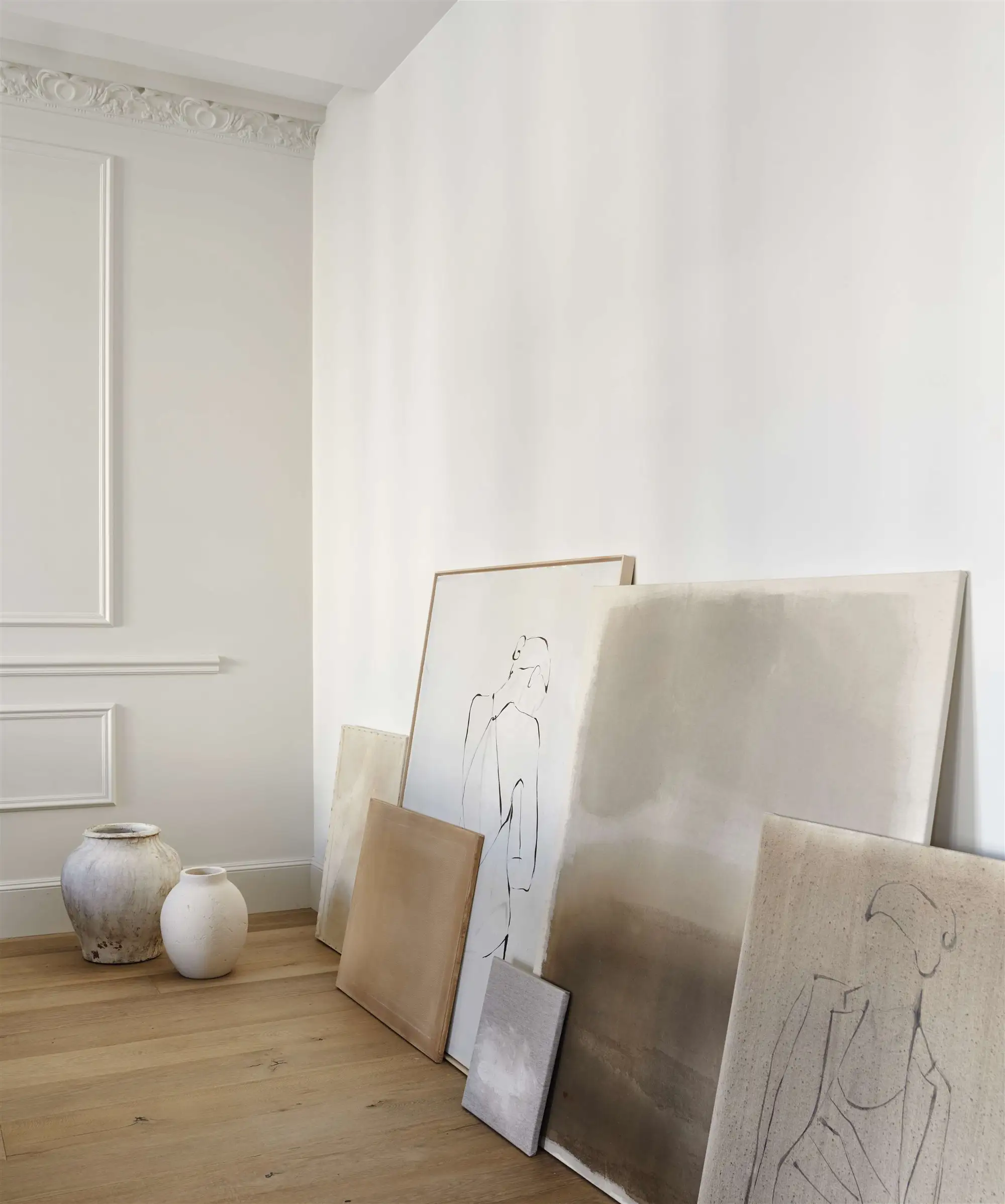 Salón con cuadros apoyados en la pared de yb apartamento en A Coruña de Nomad Interiors 