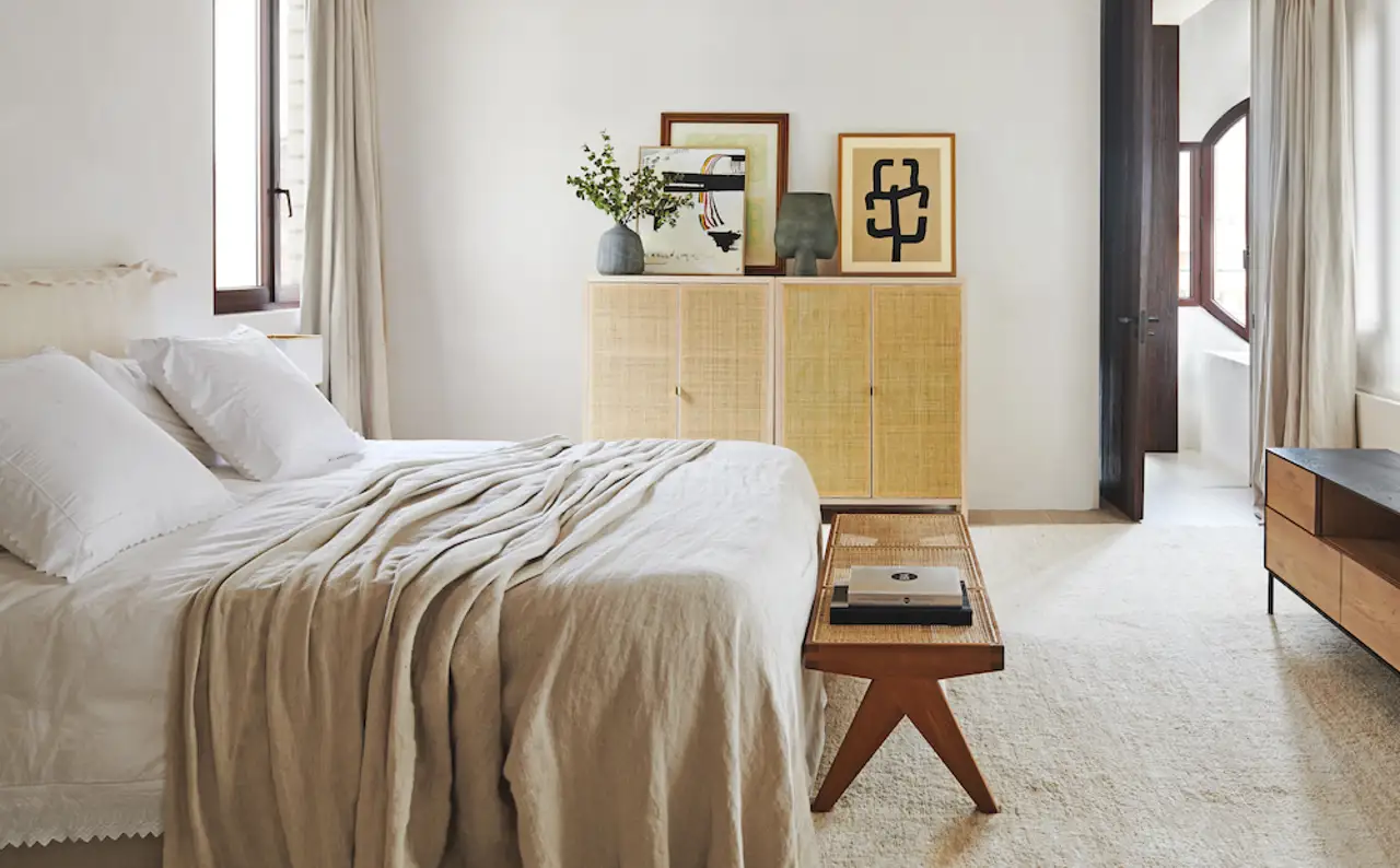 Dormitorio con cuadros sobre un mueble auxiliar