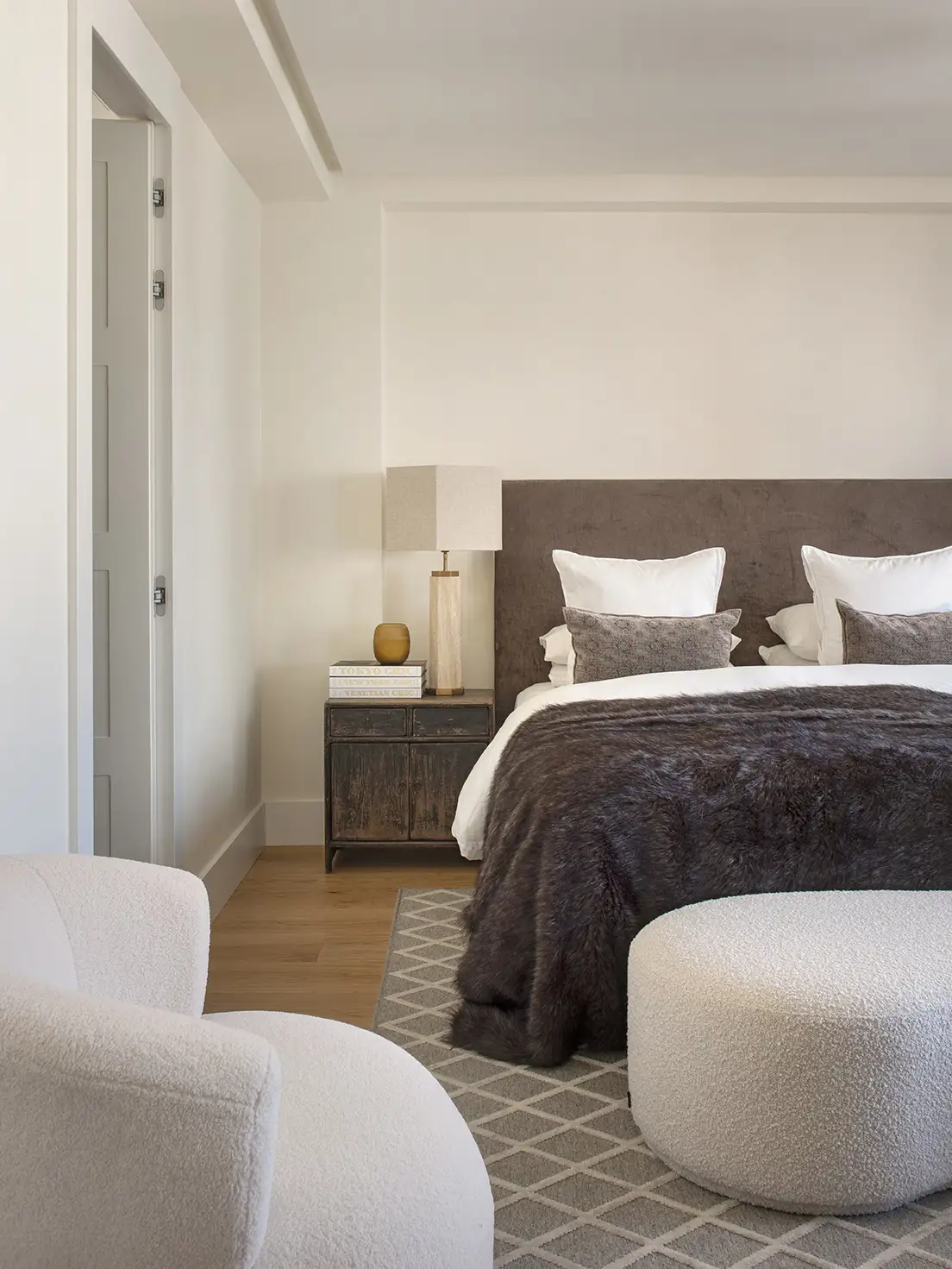 Dormitorio con cabecero tapizado y suelo de madera