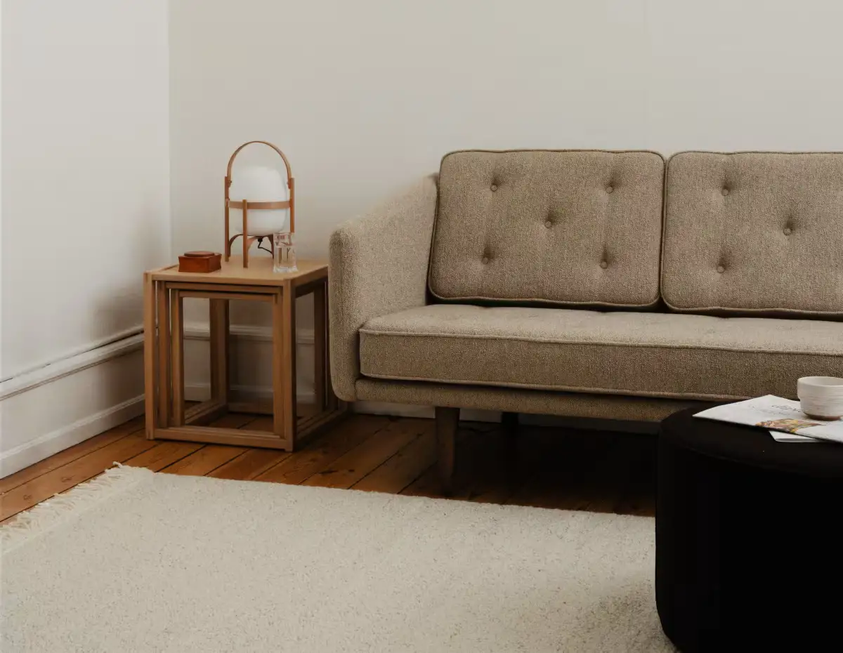 Salón con sofá de dos cuerpos, mesita y lámpara portátil