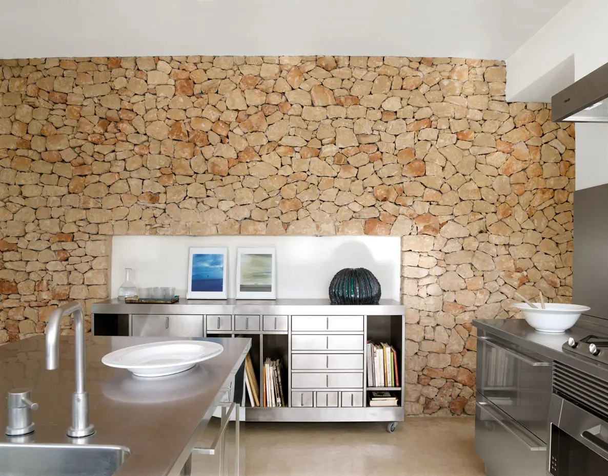 cocina de aluminio y pared de piedra
