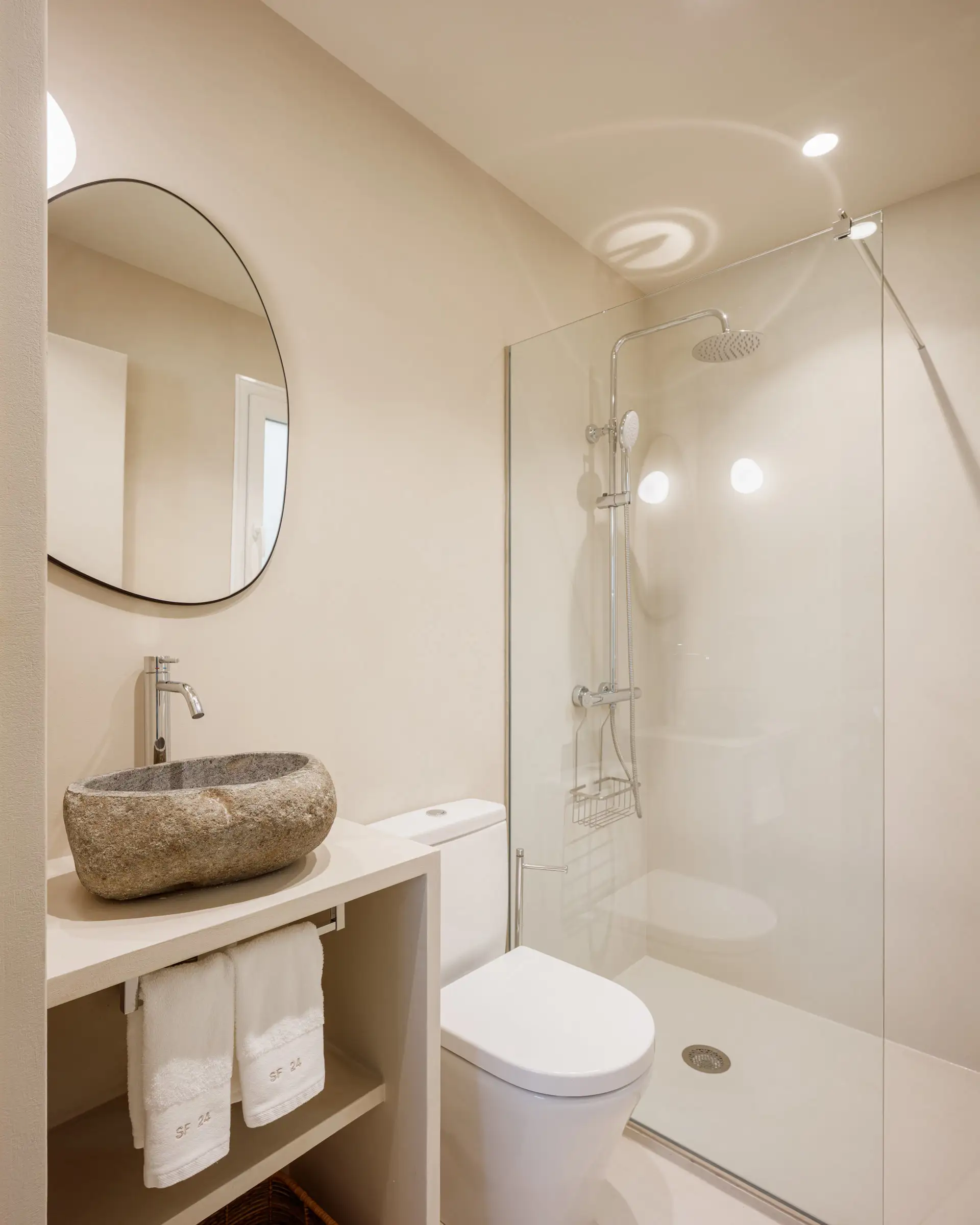 baño con estética minimalista y lavabo de piedra