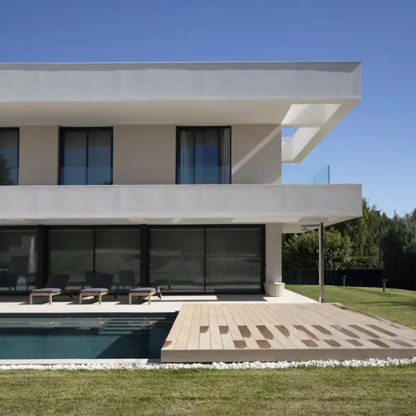 Una casa minimalista en forma de L que maximiza la luz natural y fusiona arquitectura moderna con el entorno natural