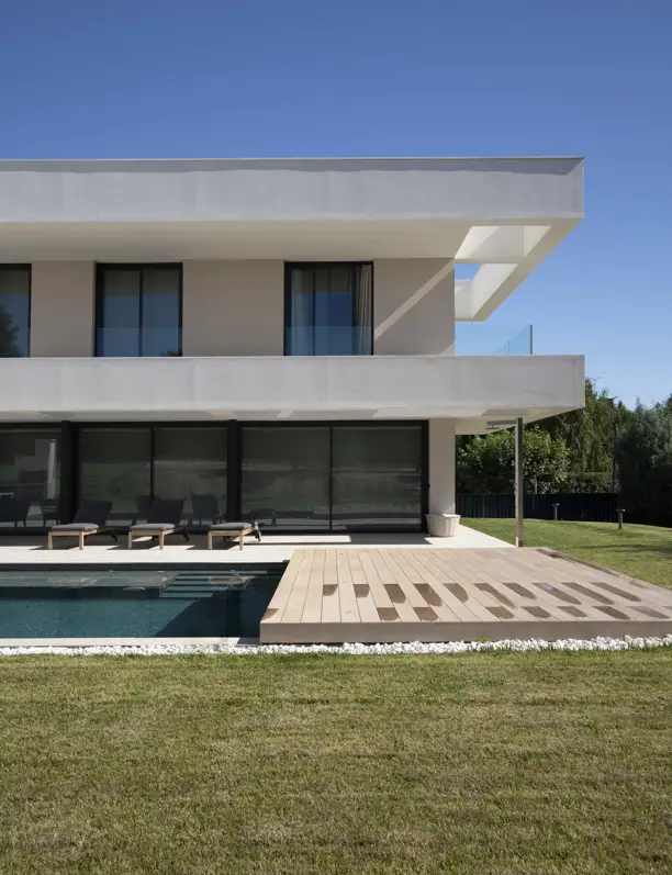 Una casa minimalista en forma de L que maximiza la luz natural y fusiona arquitectura moderna con el entorno natural