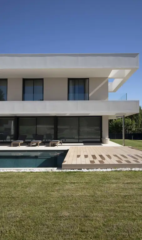 Una casa minimalista en forma de L que maximiza la luz natural y fusiona arquitectura moderna con el entorno natural