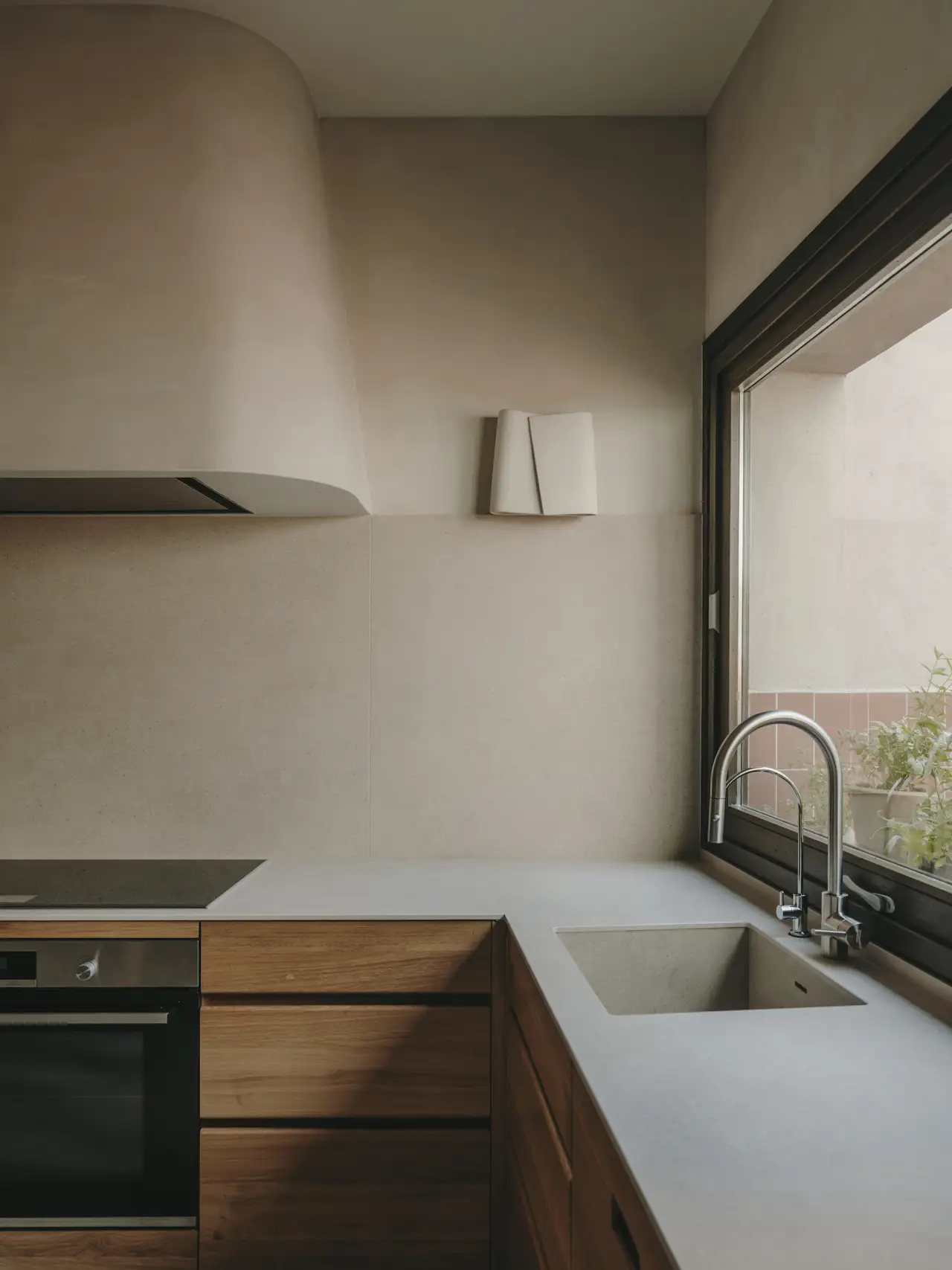 Cocina en tonos neutros con muebles de madera en una vivienda en Barcelona. Proyecto: Cristina Cirera