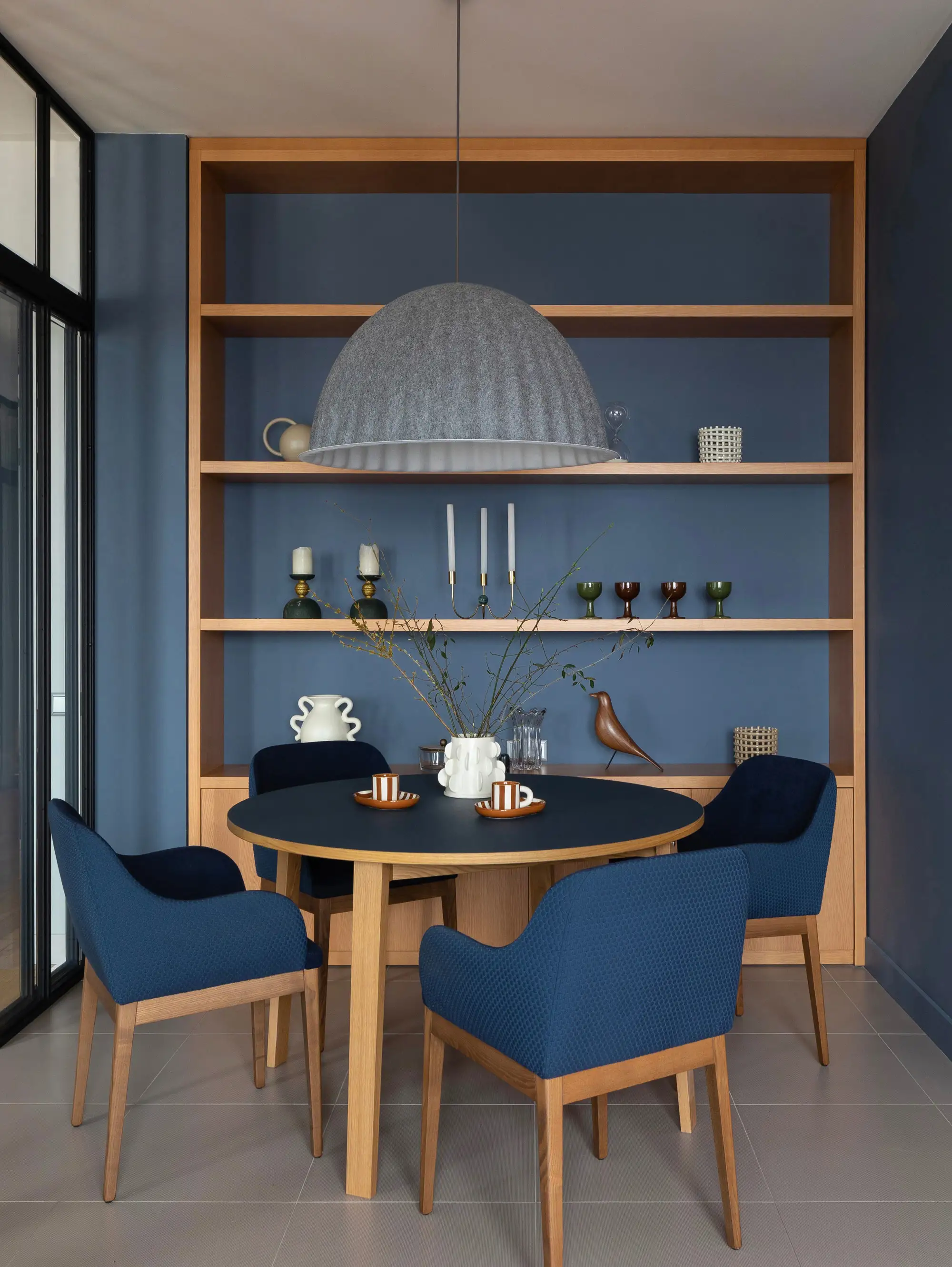 comedor con pared azul oscuro y mueble empotrado YanaMolodikh