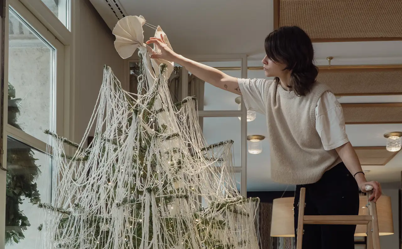 Alba Galocha poniendo el broche final al árbol de Navidad en forma de lazo