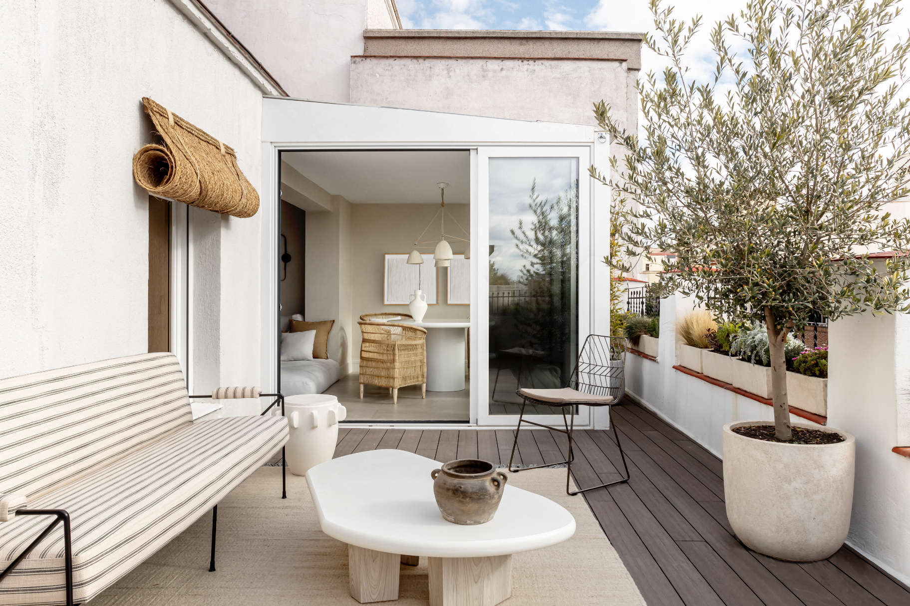 La terraza de este ático en Madrid se ha vestido con un sofá de Decolab; alfombra de Zigler, y mesa de centro y taburete de Findings Gallery. La silla y la vasija, de Tristán Domecq Casa.