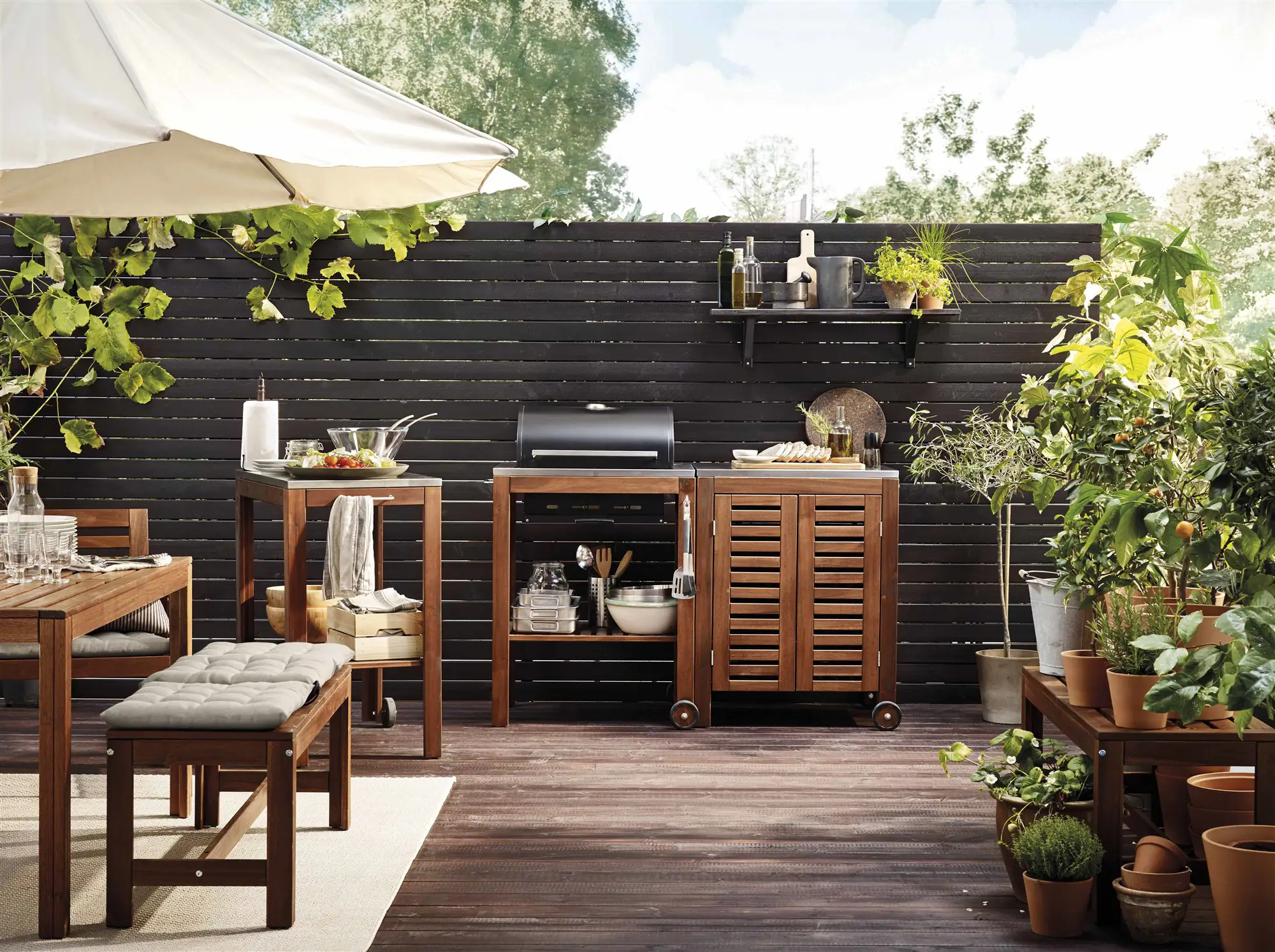 Patio de madera con barbacoa, cenador y plantas