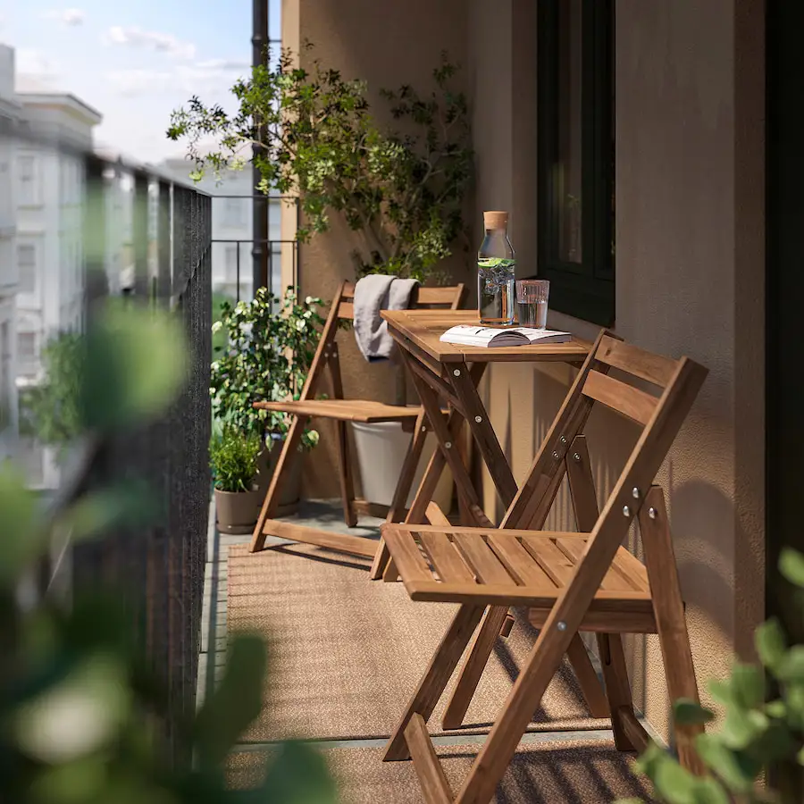 Balcón pequeño con sillas y mesa de madera