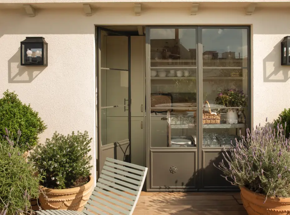 puerta verde que va a dar a una terraza con macetas