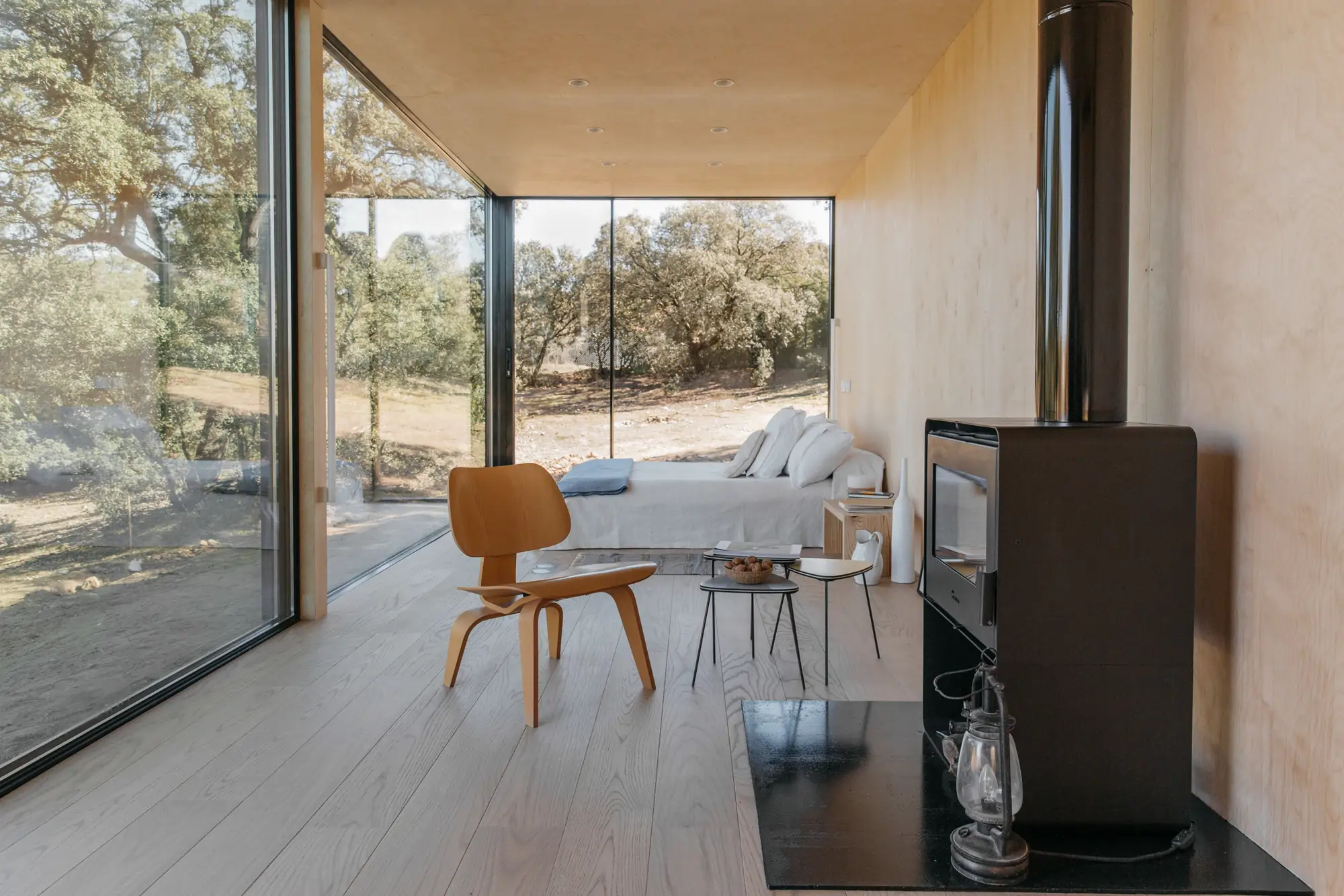 una silla al lado de una chimenea en una cabana de madera y ventana de cristal