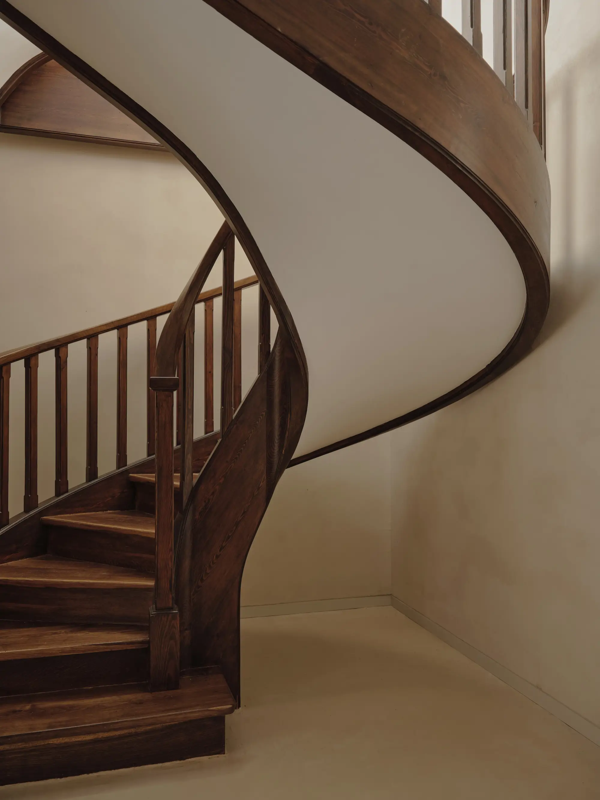 una escalera de madera y blanco en curva
