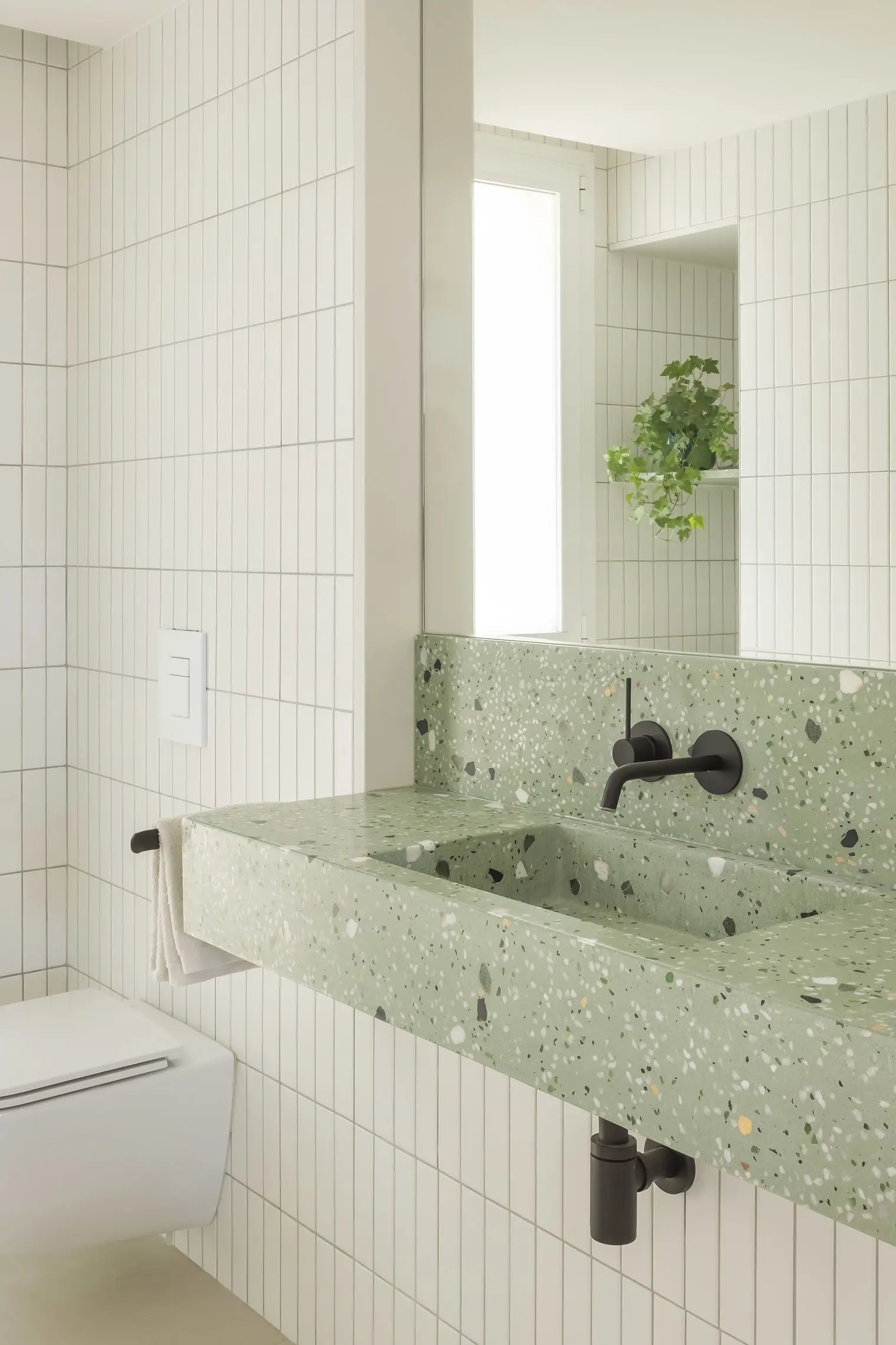 En uno de los baños se ha escogido un lavabo de terrazo en color verde