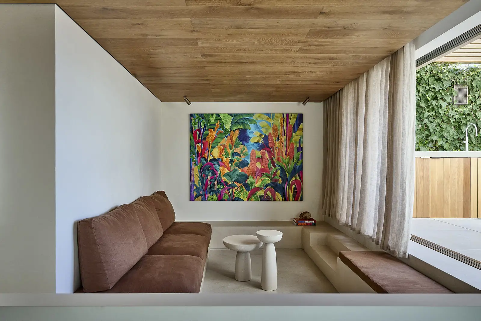 sofa terracota apoyado en pared y un cuadro de colores