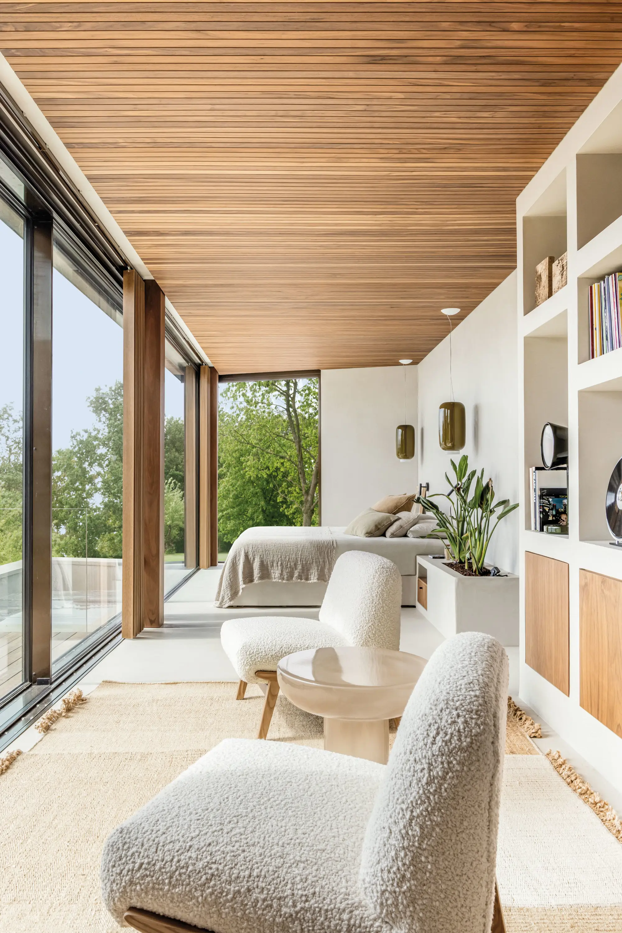 Dormitorio con sala de estar, estantrería y sillones de bouclé