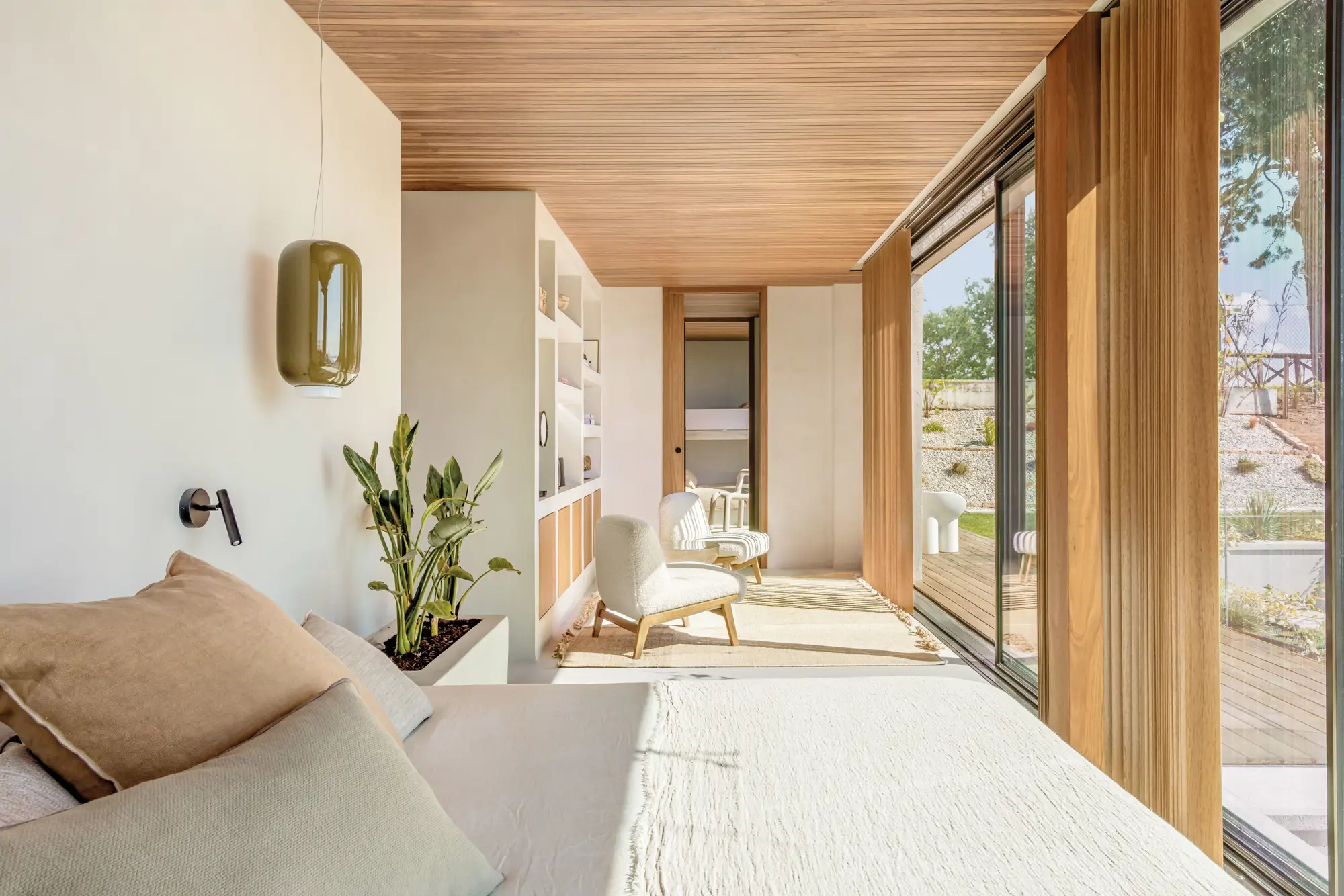 Dormitorio con sala de estar y pared del cabecero blanca