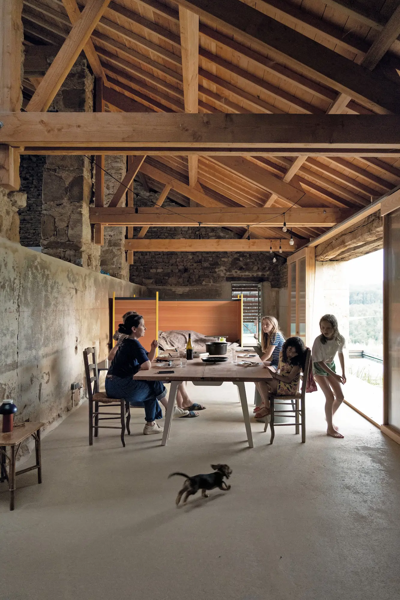 Comedor abierto para ver cómo se transforma el paisaje, con la piscina de filtración natural, al fondo.