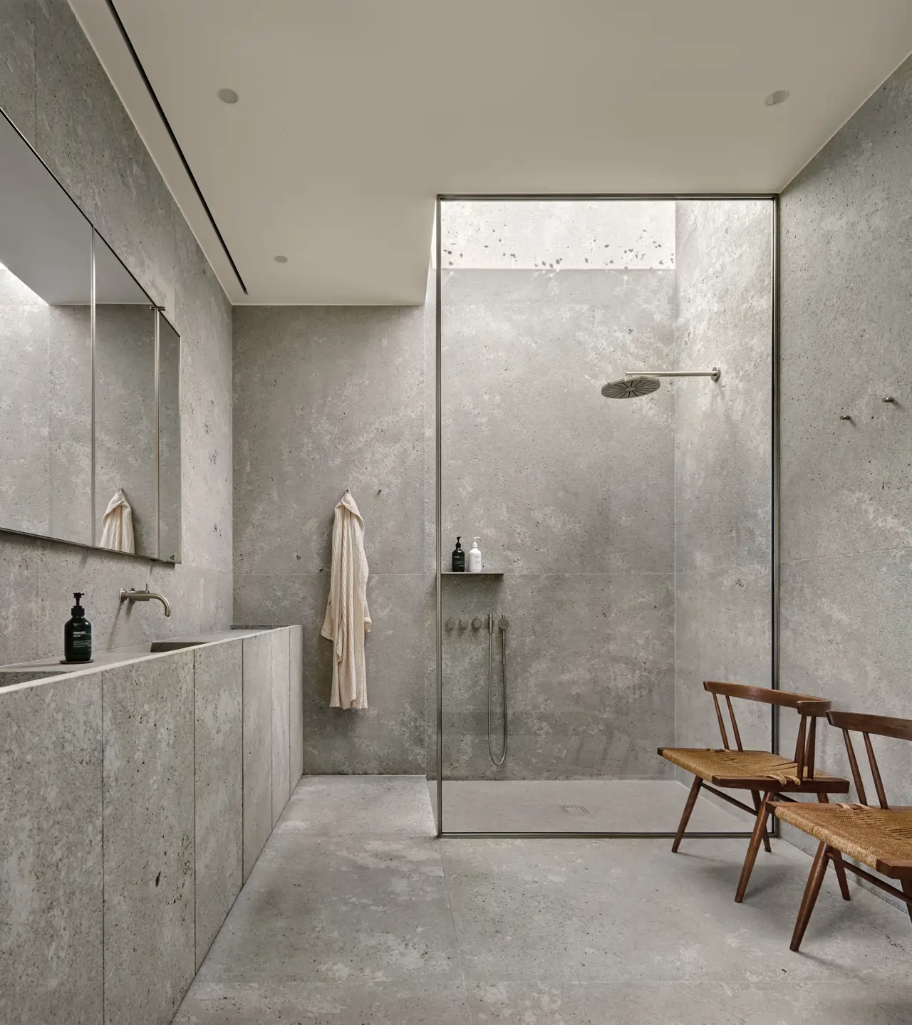 Baño de hormigón de estilo brutalista con mampara fija