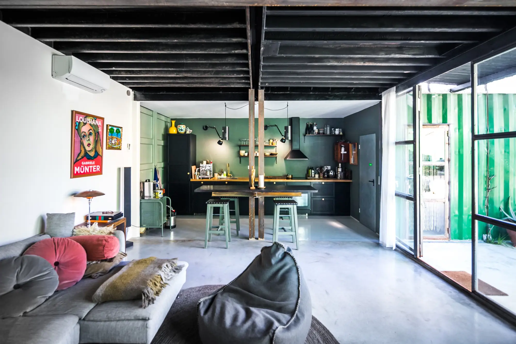sofa gris y una cocina al fondo de color verde