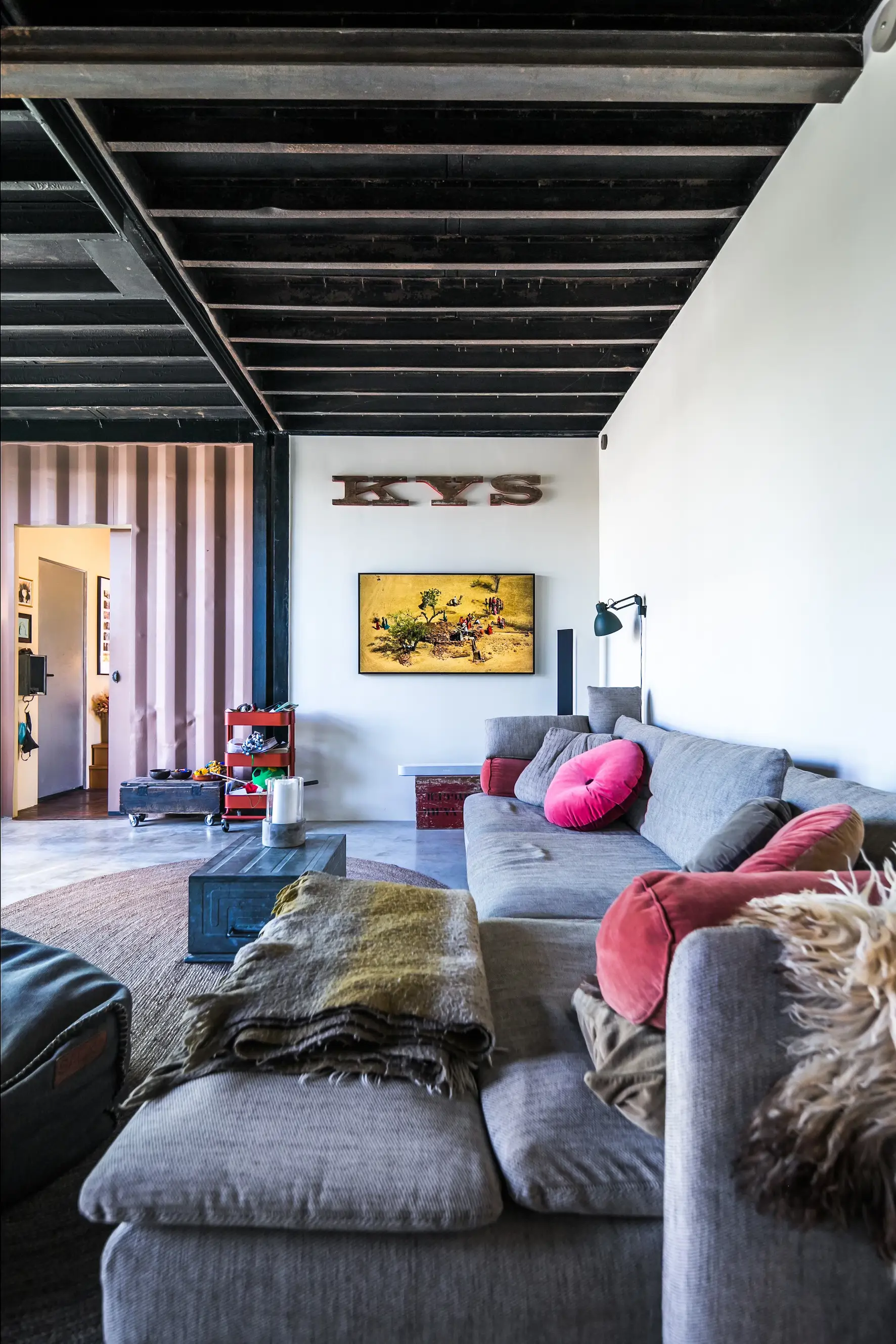 sofa gris con cojin rosa y techo negro