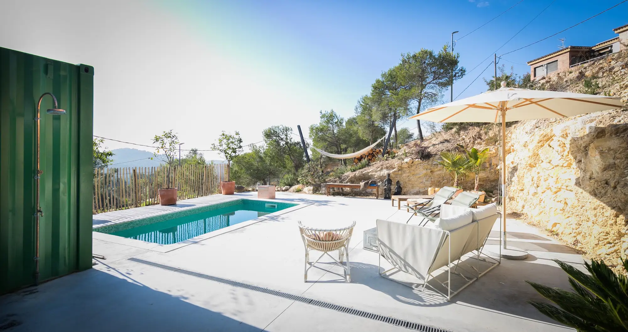 piscina con sofas y una sombrilla