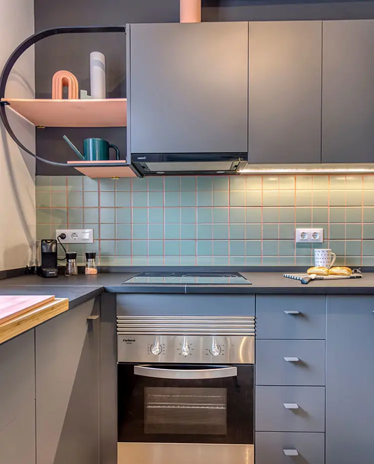 Detalle de zona de cocción de cocina con mobiliario en gris y salpicadero en turquesa. Proyecto: Insayn Design Society