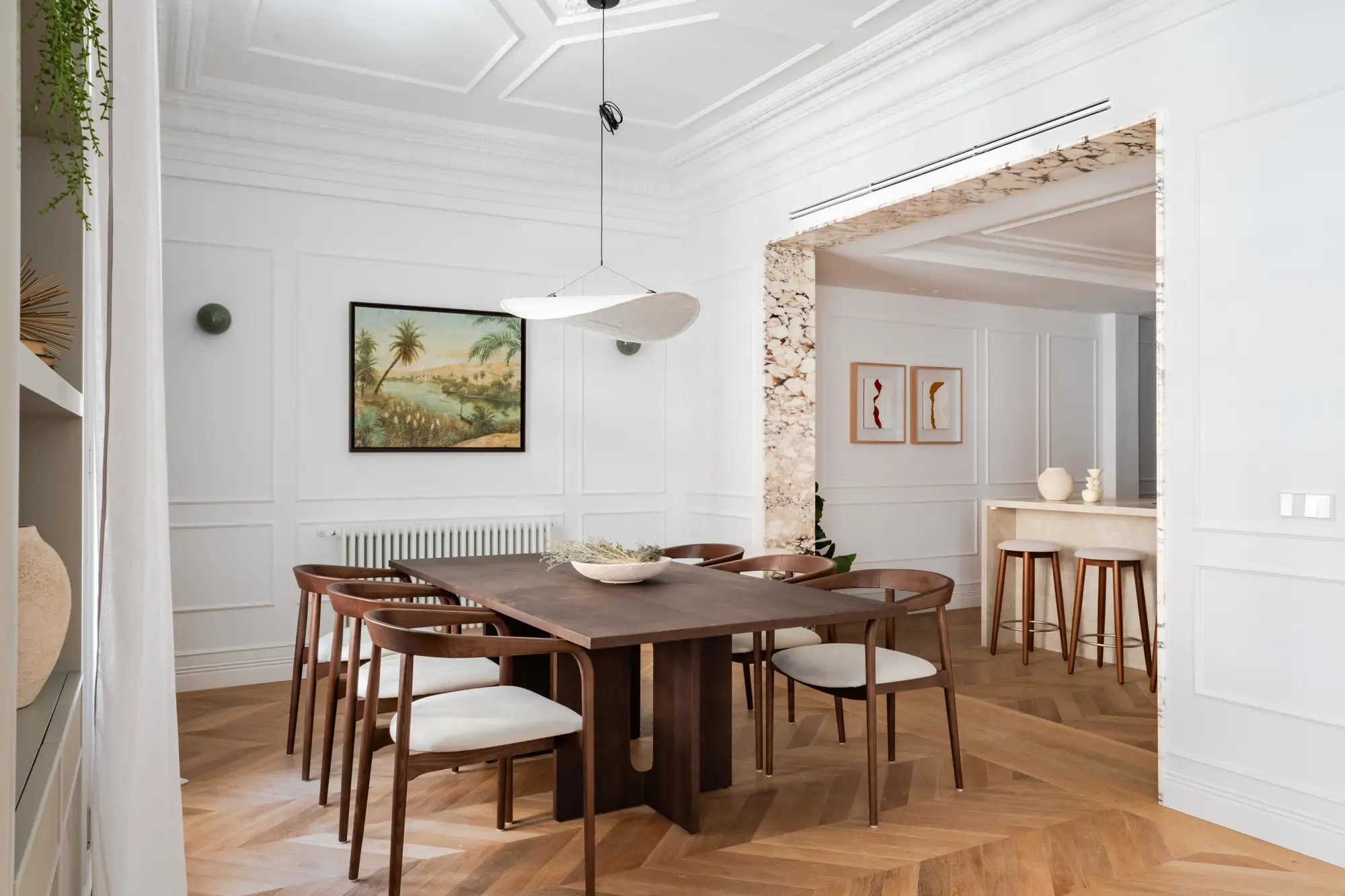 Comedor de madera oscura y salón con molduras